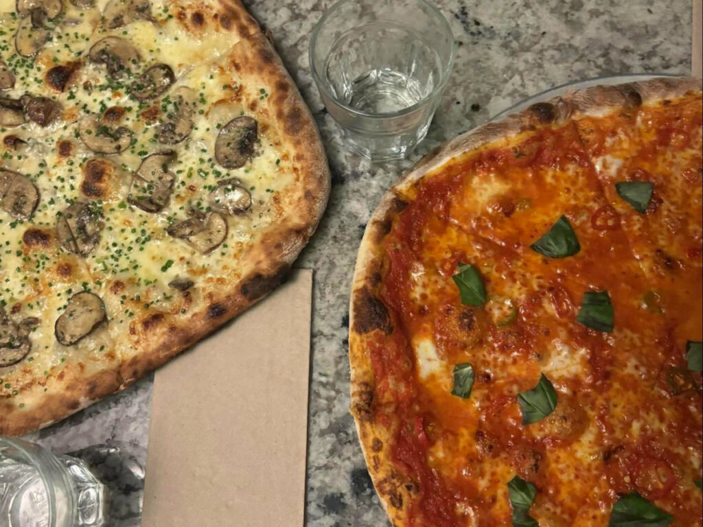 Mushroom and gorgonzola pizza on the table with glasses of margherita at Errol’s Hot Pizza