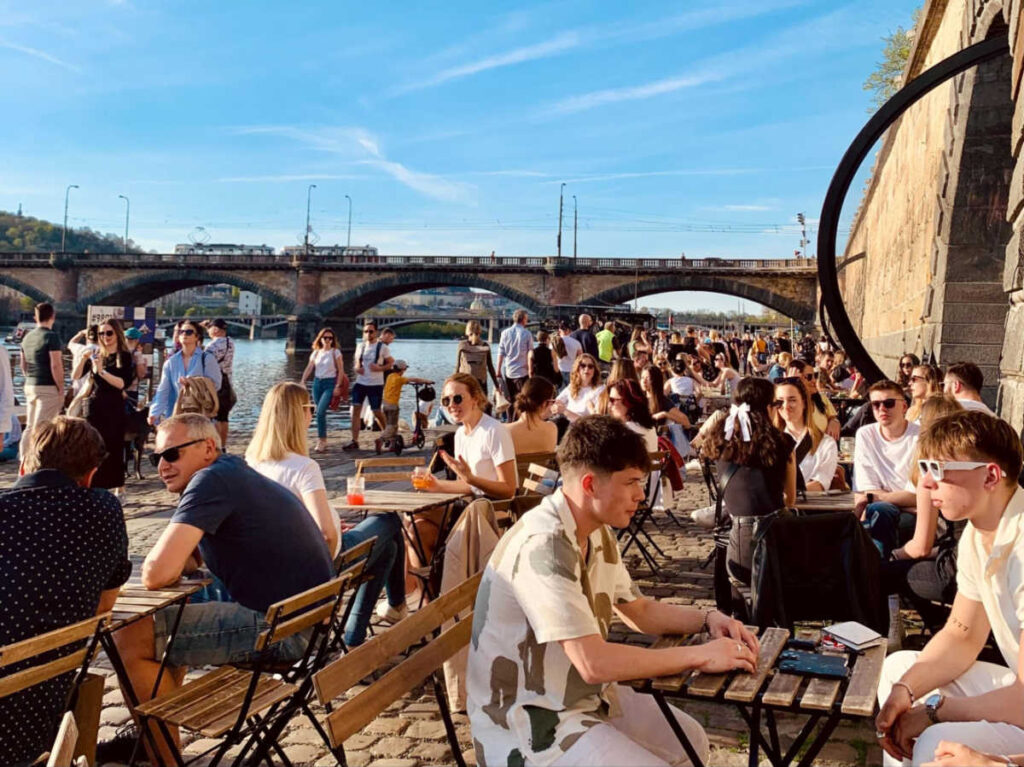 The crowd enjoying at the riverside cafes and bars at the Rašínovo embankment