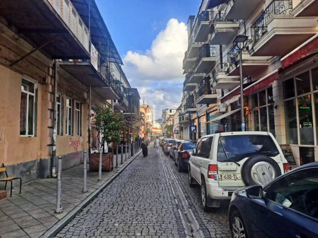 Cars parked on the side of a narrow street in Batumi