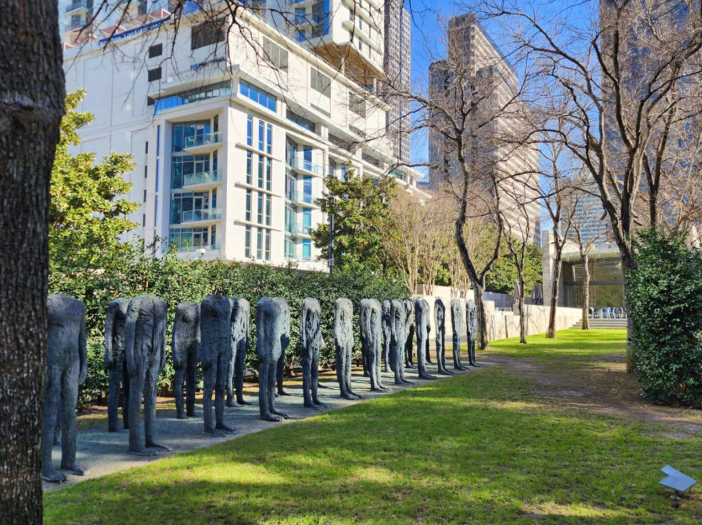 Group of statues in park with tall buildings in background, at Nasher Sculpture Center