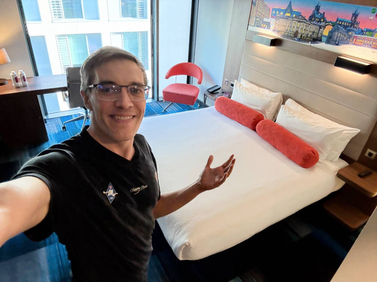 Nate Hake smiling for a photo inside his room at The Aloft Dublin City