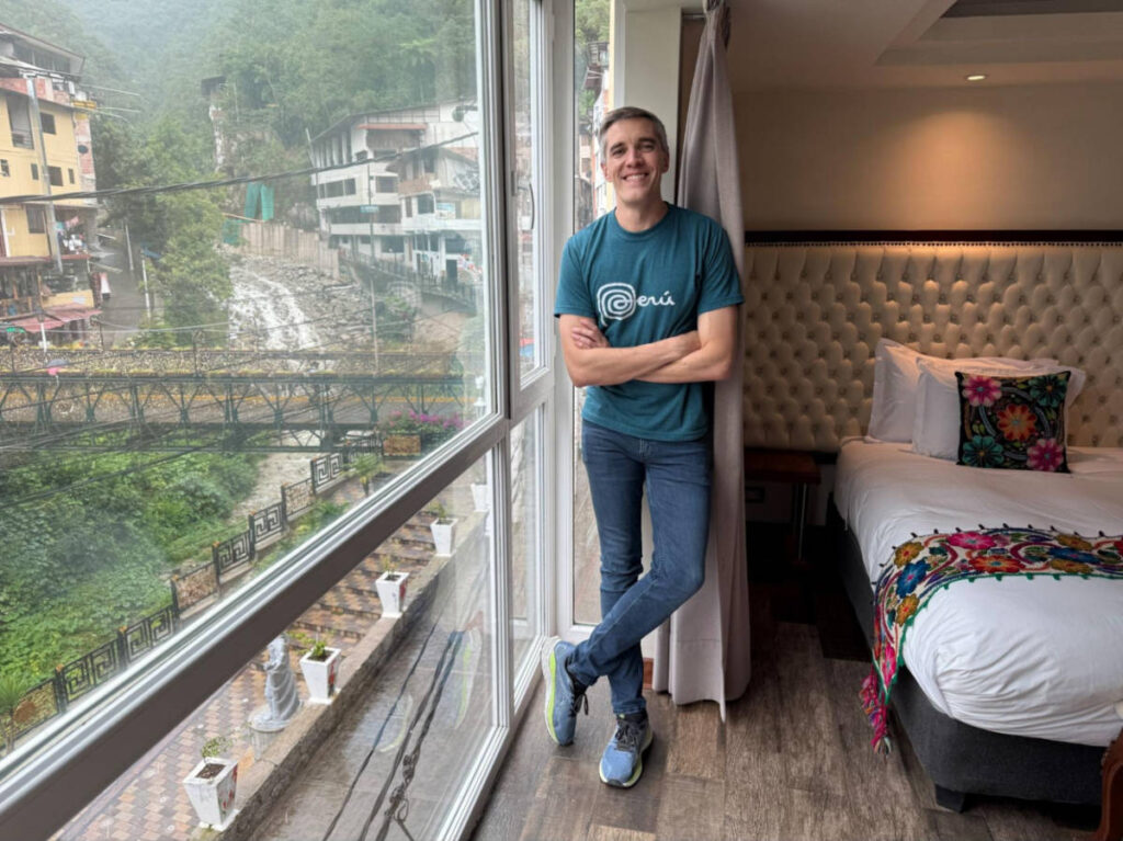 Travel Lemming founder Nate Hake, posing for a photo inside the river-view room at Jaya Machu Picchu Boutique Hotel