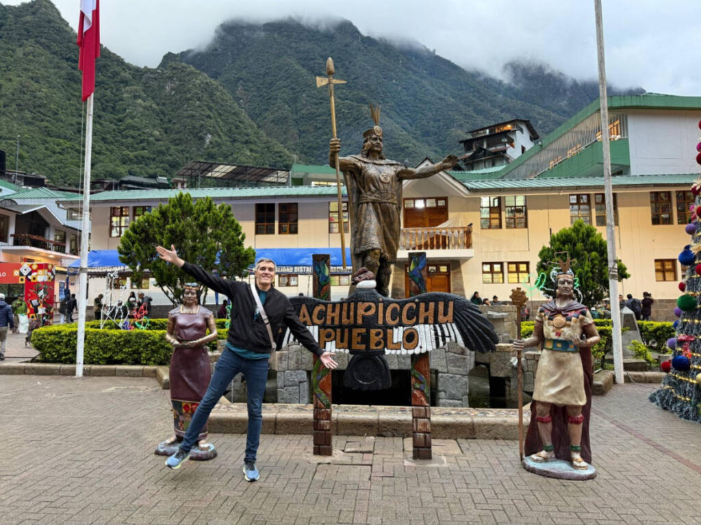 Travel Lemming founder Nate Hake, posing in front of the statue at Machu Picchu Pueblo’s tiny town square