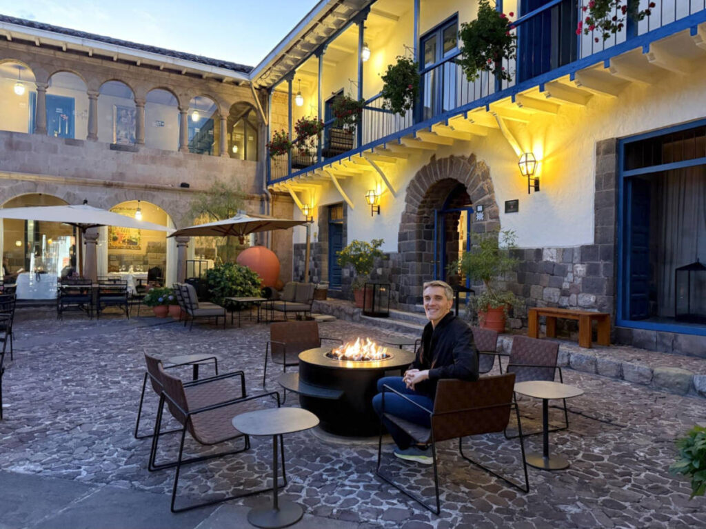 The author Nate Hake, enjoying the fire at the hotel courtyard of Palacio del Inka