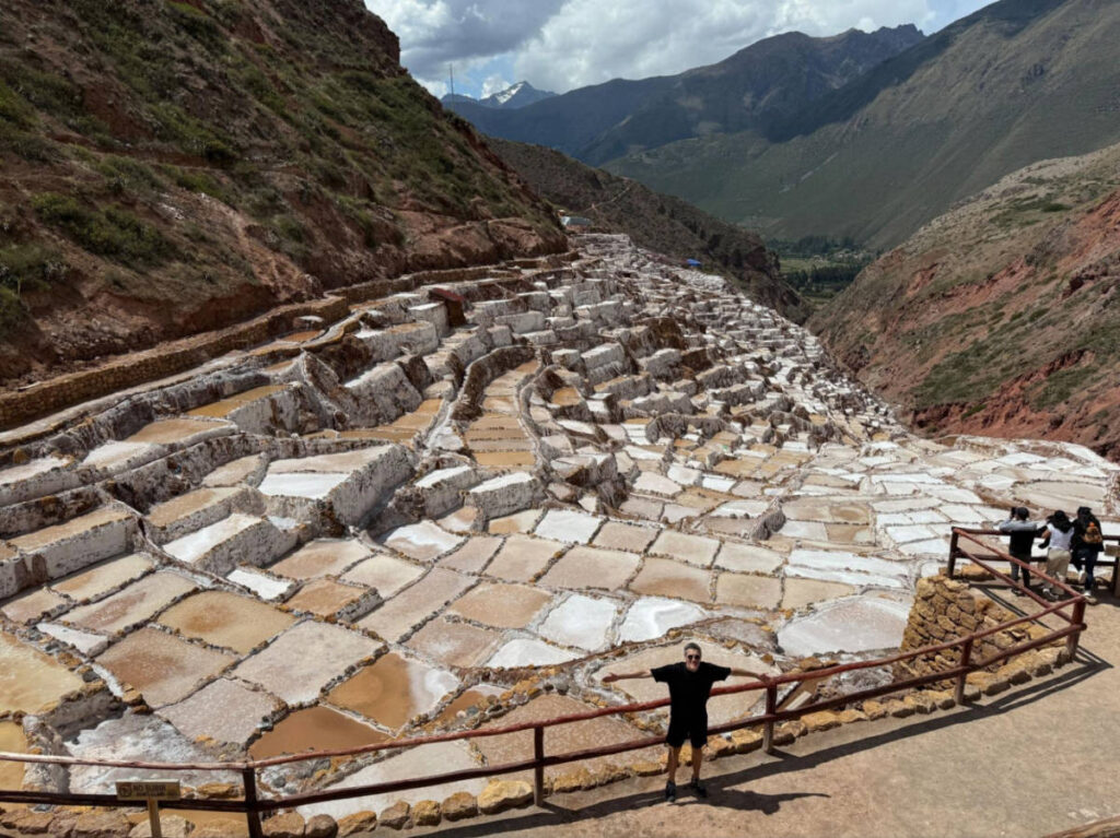 Travel Lemming founder Nate Hake, posing for a photo with an overlooking view at the Salineras de Maras