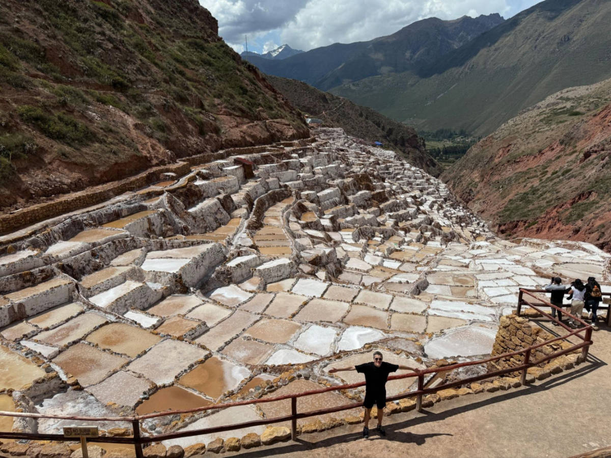 Travel Lemming founder Nate Hake, posing for a photo with an overlooking view at the Salineras de Maras