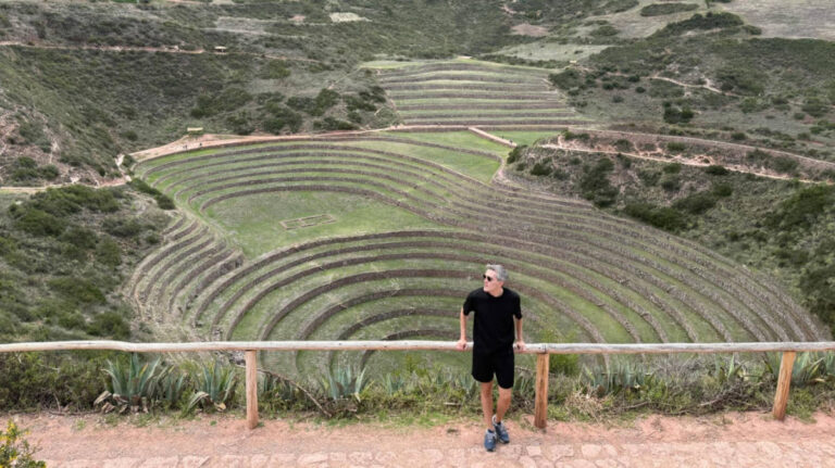 Travel Lemming Founder Nate Hake, standing at the top with an overlooking view of the Ancient Ruins of Moray
