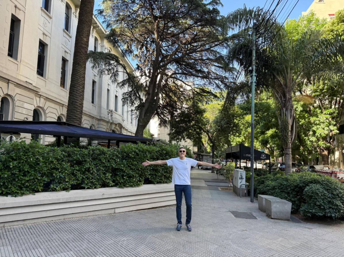 Travel Lemming founder, Nate Hake, posing for a photo near the entrance to Uptown bar surrounded by greenery