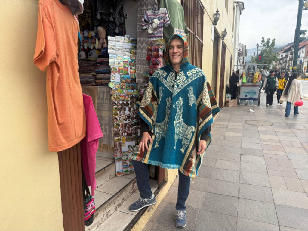 Travel Lemming founder Nate Hake, wearing an alpaca poncho outside the shop