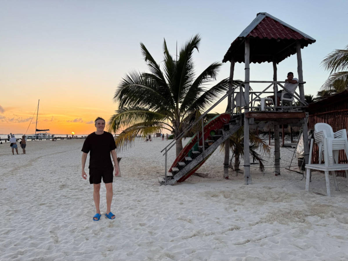 Travel Lemming founder Nate Hake on Isla Mujeres with sunset view in the background
