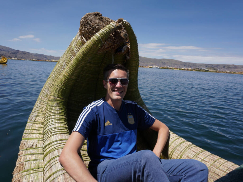 Travel Lemming Founder Nate Hake, riding on a traditional reed boat in Lake Titicaca