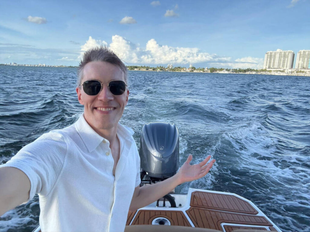 Travel Lemming founder, Nate Hake enjoying the boat ride with skyline views behind