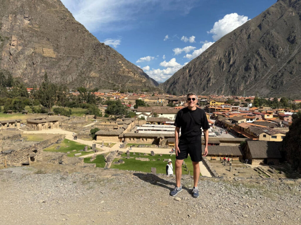 Travel Lemming founder Nate Hake, standing at the Ollantaytambo ruins with an overlooking view of the town in the background