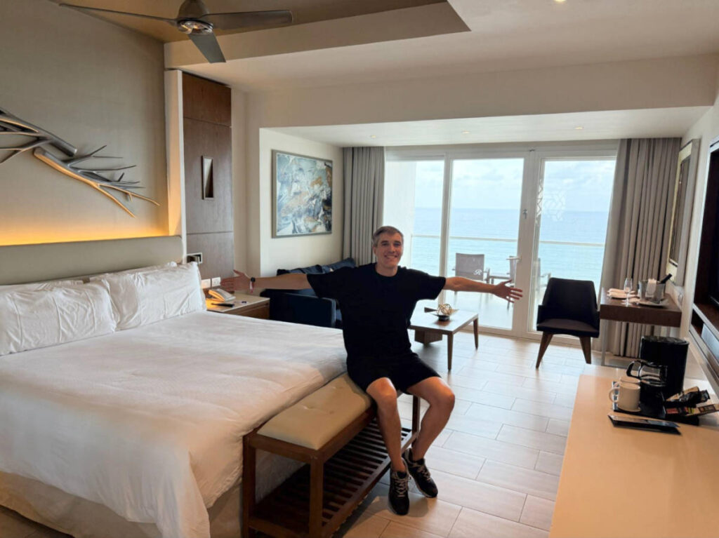 Travel Lemming founder Nate Hake, sitting on his bed at the Royalton CHIC Adults-Only