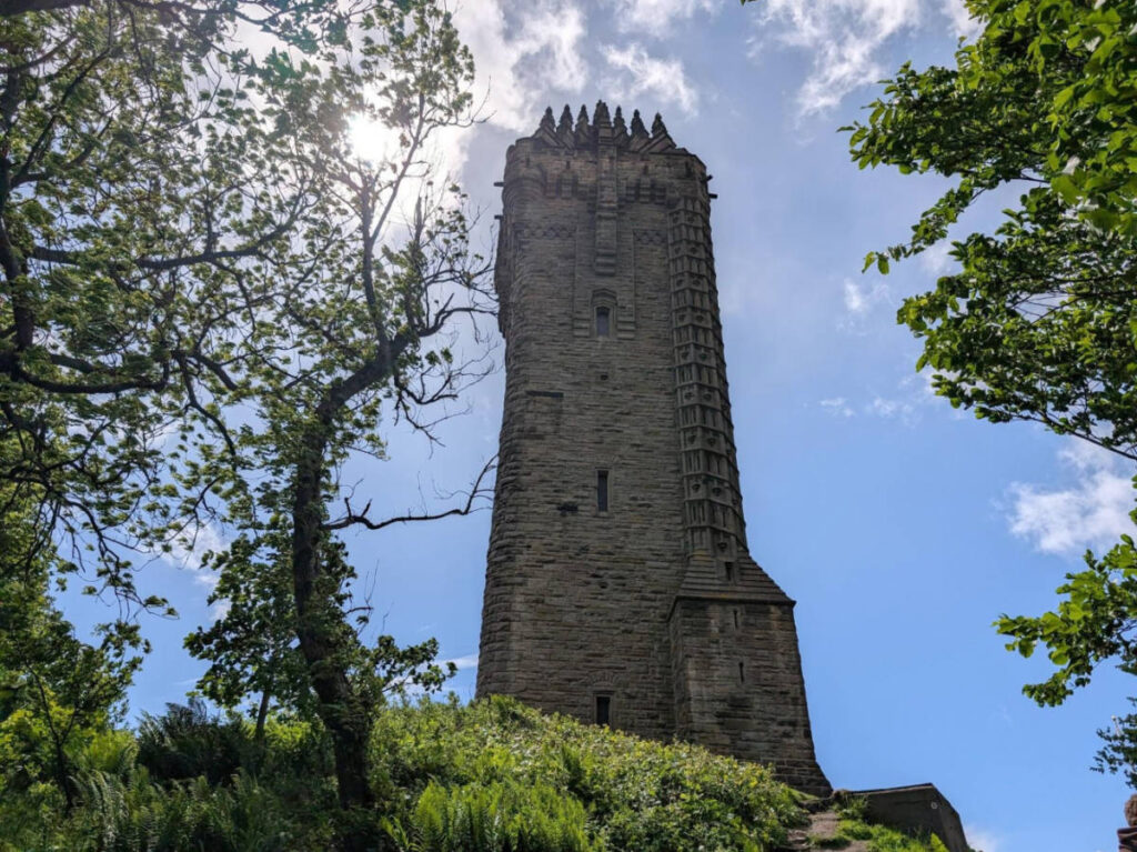 View of the National Wallace Monument surrounded by greenery on top of the Abbey Craig Hill