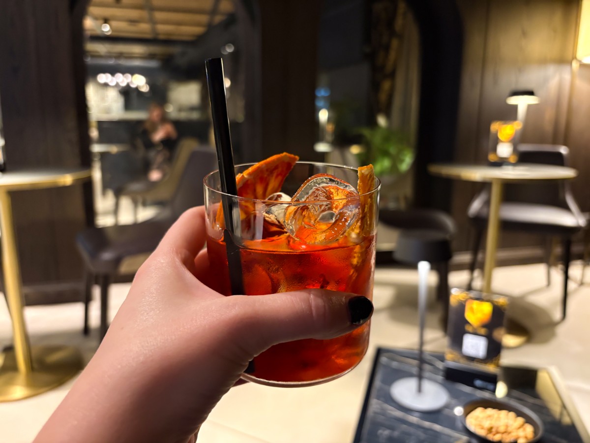 Holding a glass of Negroni at The Mask American Bar