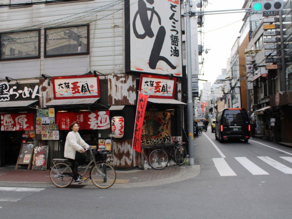 A woman biking at the Namba neighborhood in Osaka