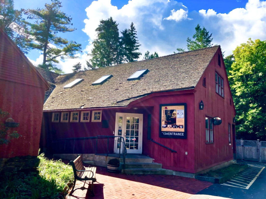 View of the red exterior and white front door of Noah Webster House and Museum on a sunny day