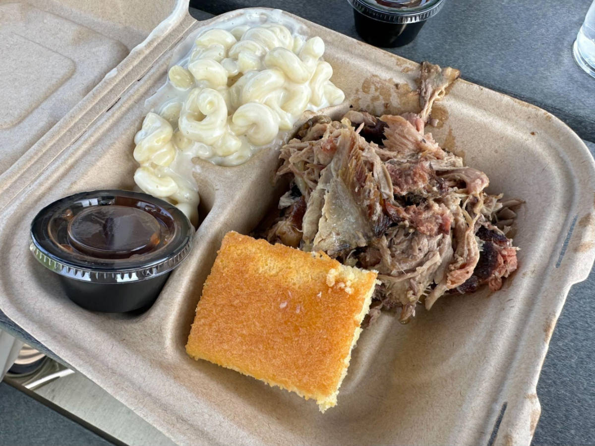 Closeup look of a pulled pork barbecue, mac n cheese, and cornbread