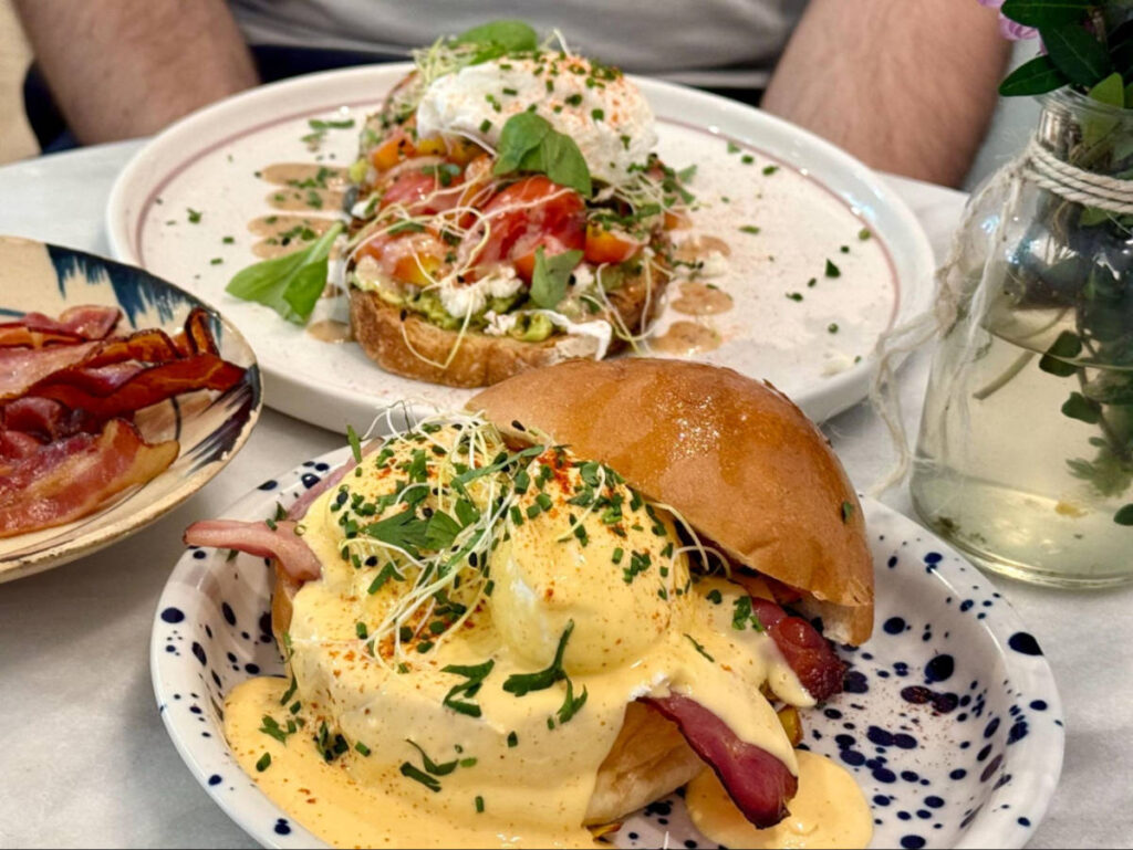 The eggs benedict and avocado toast on a plate at Ô-Mai