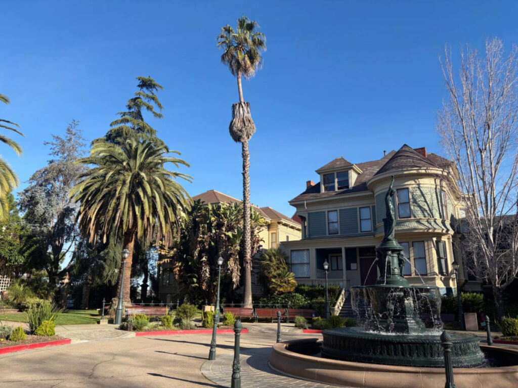 A fountain in front of the old Victorian building in Preservation Park