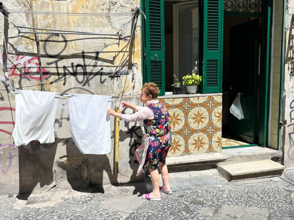 An old woman drying clothes on a sunny day