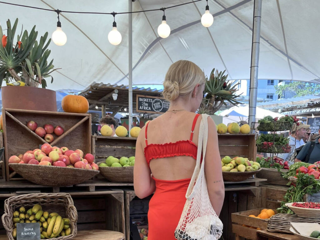 A woman looking at the food stall in Oranjezicht Market