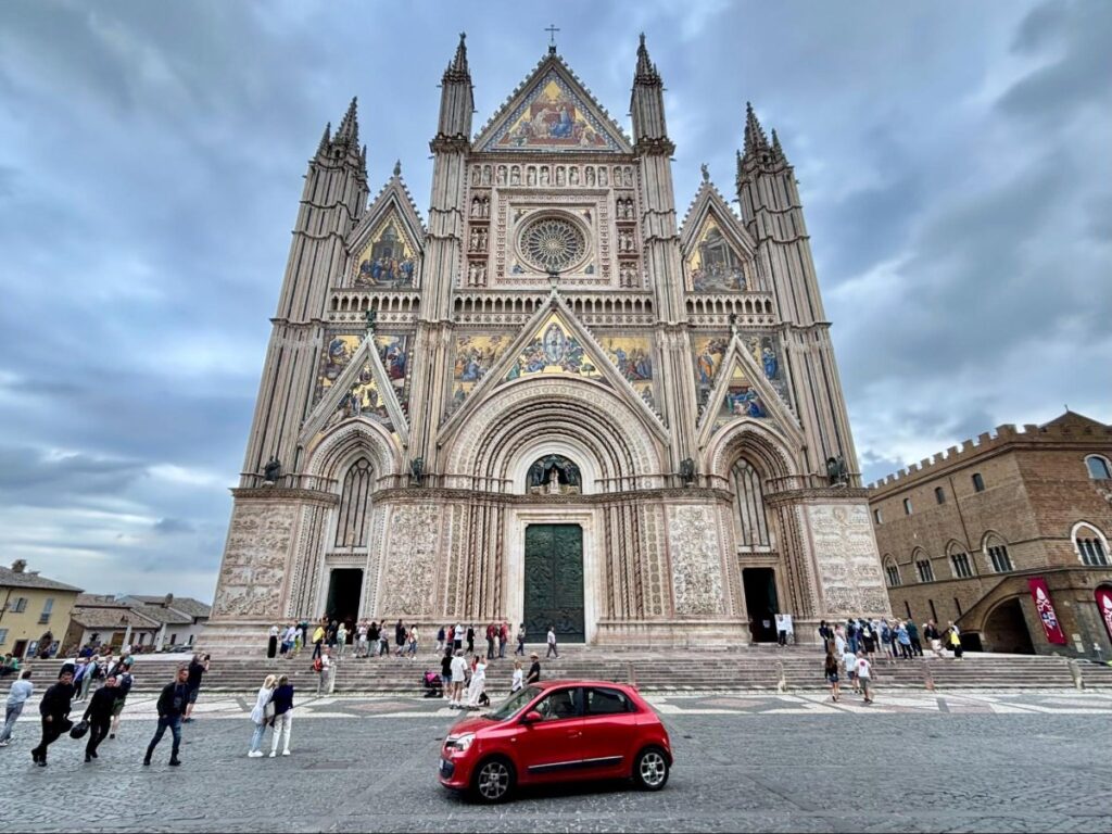A red car in front of Orvieto Cathedral