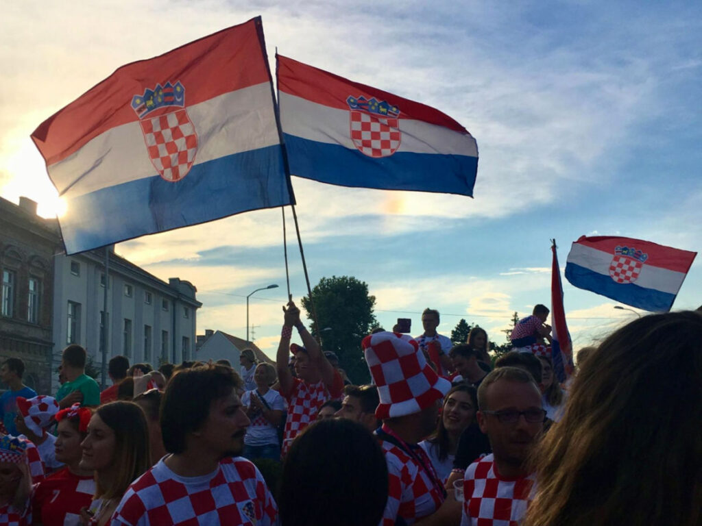 People waving the Croatia Flag at an Outdoor watch party for the World Cup