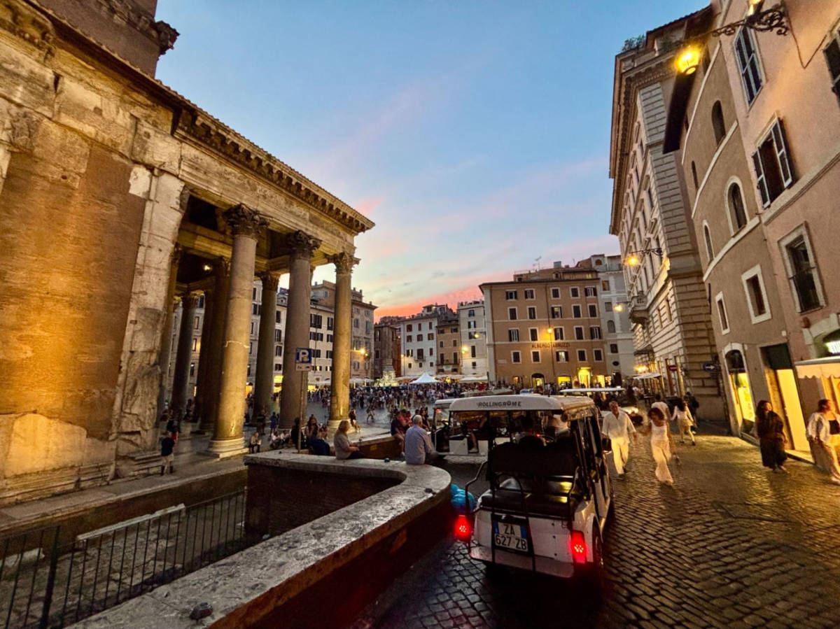 A golf cart parked outside the crowded Pantheon at dusk