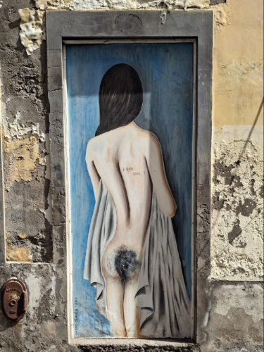 View of a woman's back on the painted door in Rua Santa Maria