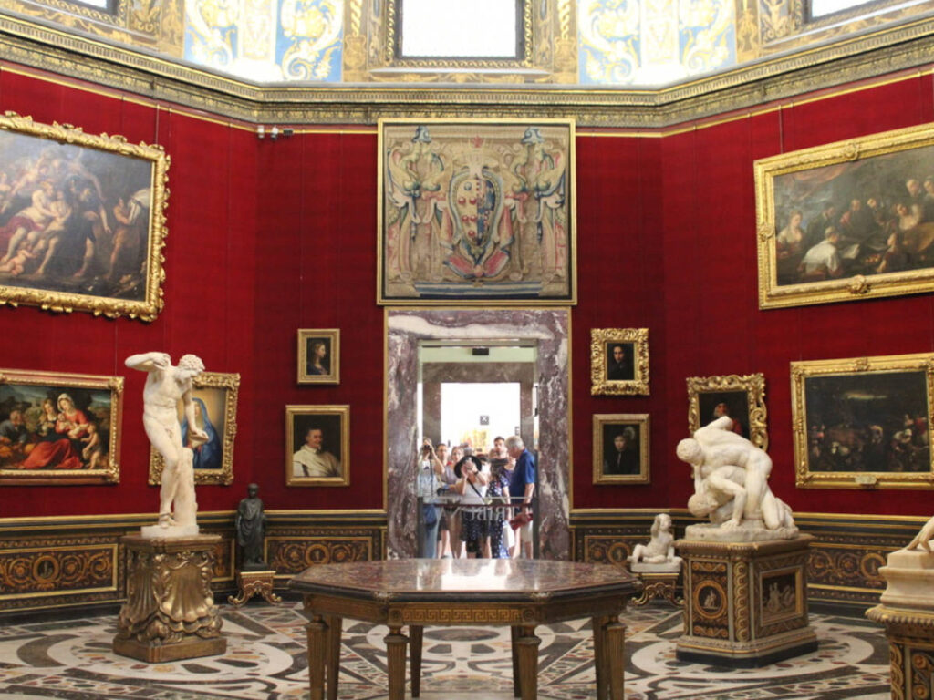 Crowd looking inside the restricted area with paintings and statues displayed in Uffizi Gallery