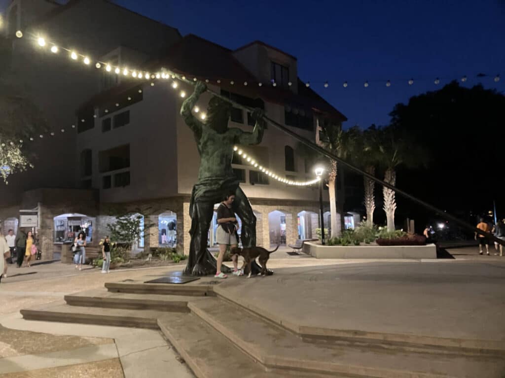 The author, Meg O’Connor with her dog and a statue at the Palmetto Dunes
