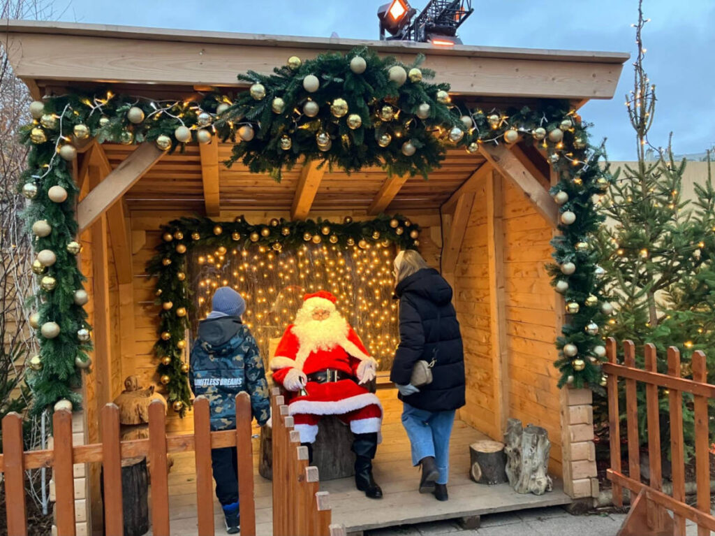 A parent and a child visiting Santa Claus at the Parisian Christmas Market