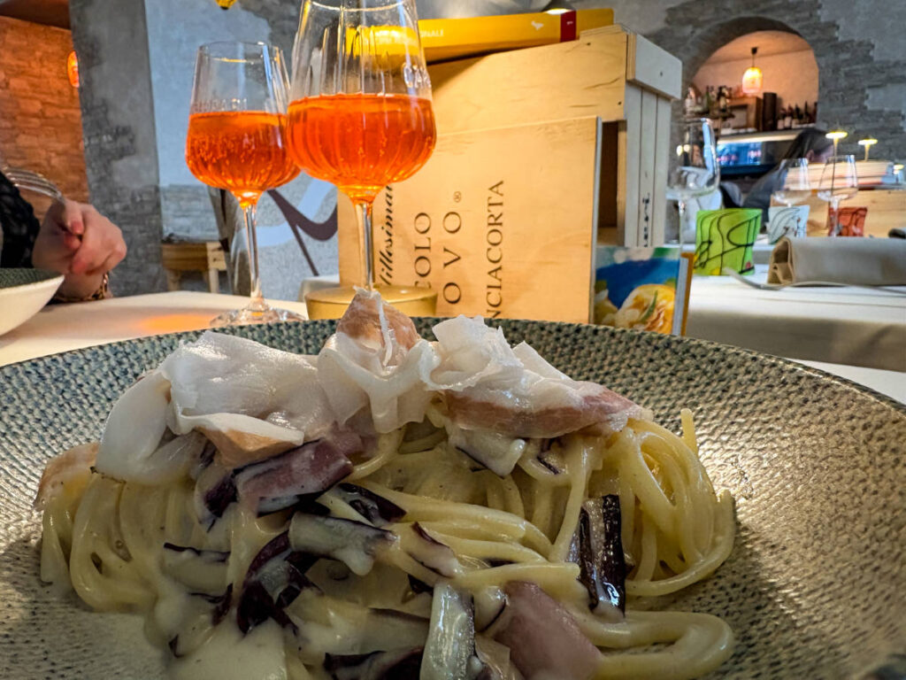 A plate of pasta and glasses of drinks at Murano Trattoria Valmarana