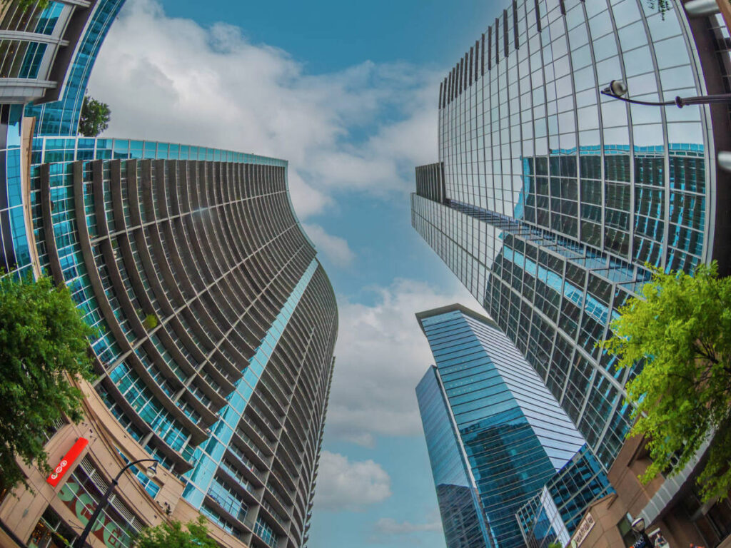 Modern glass towers that loom over Peachtree Street seen from below