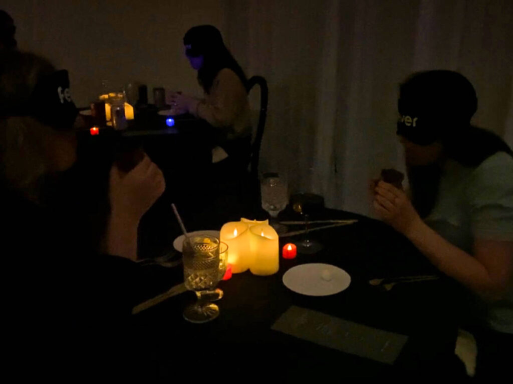 People sipping their soups on a cup while in the dark room