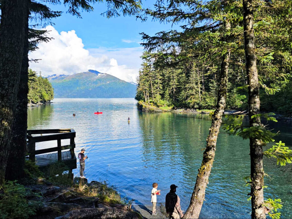 A child and the adults fishing with a scenic view around