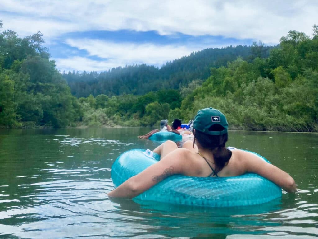 View of the people floating on the Russian River surrounded by greenery
