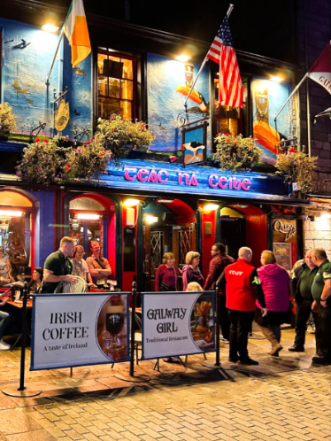 People lining up outside a pub at night