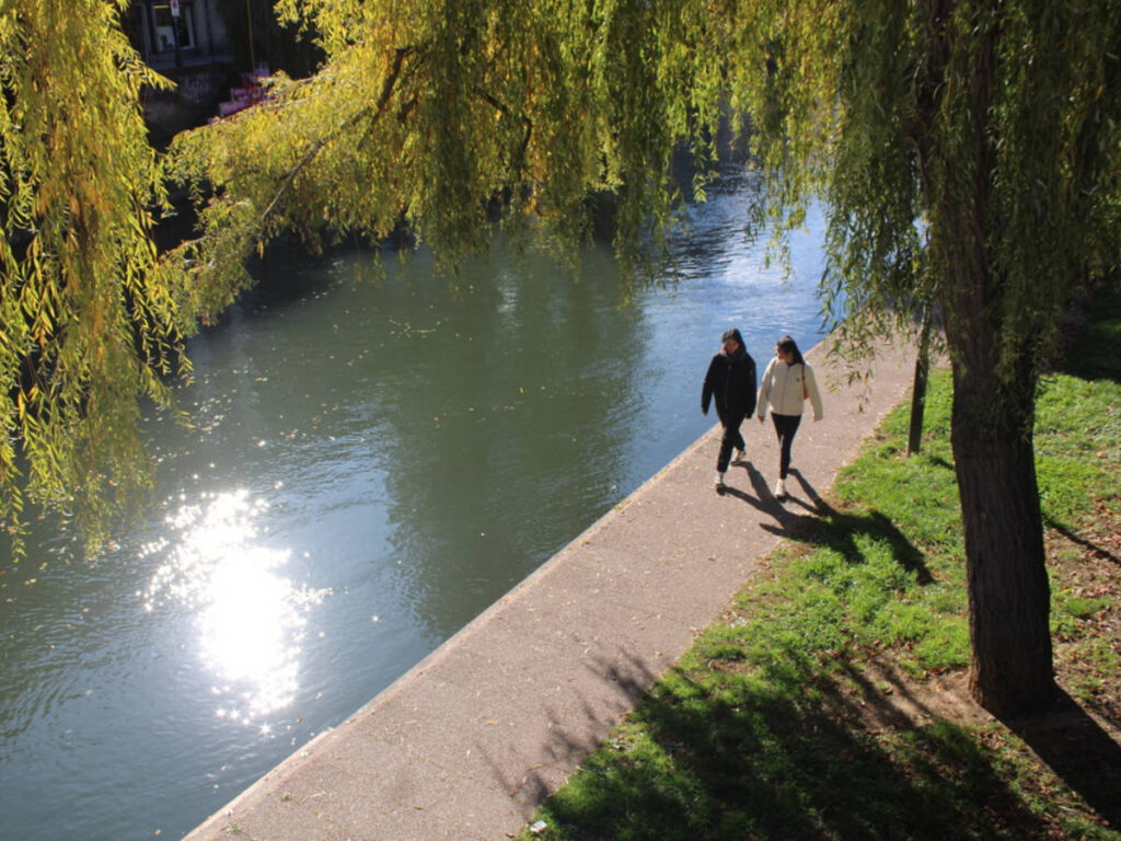 People walking along the canal in Strasbourg on a sunny day