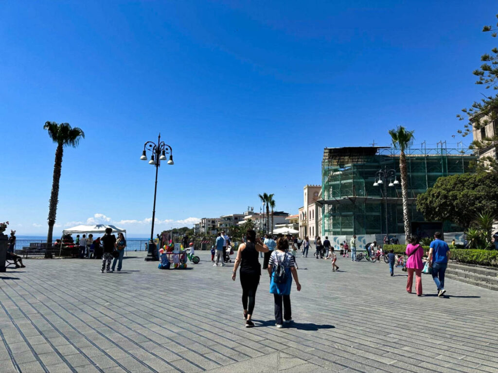 The people wandering around Aci Castello on a sunny day