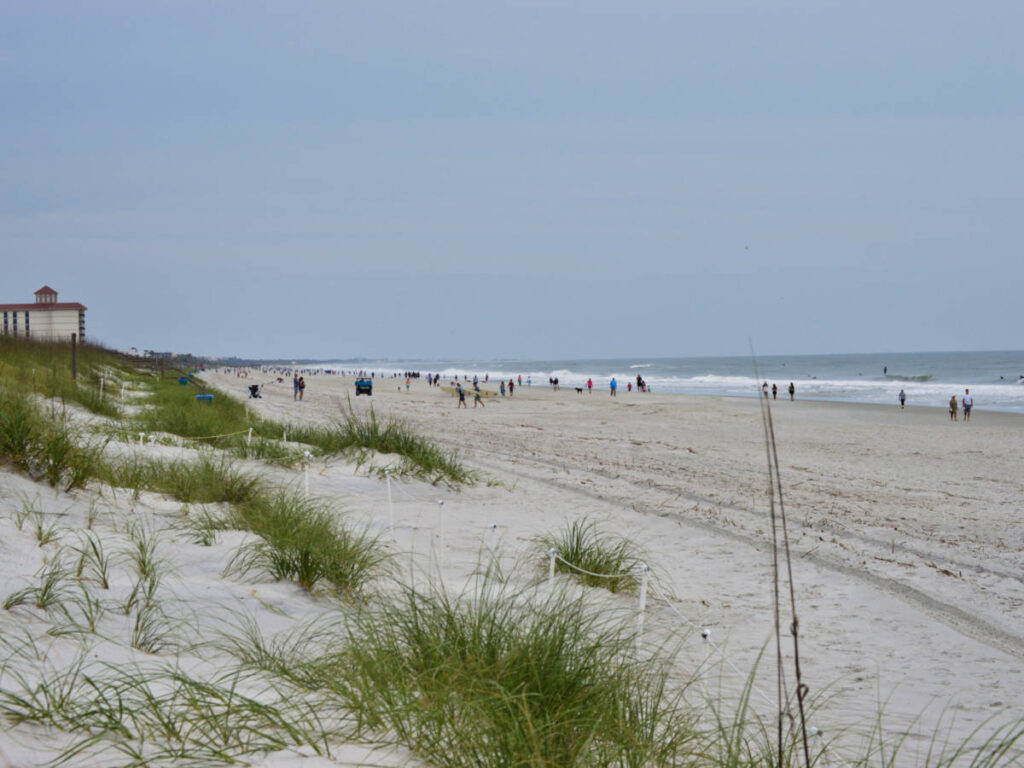 Panoramic view of the people at the white sand Neptune Beach, seen from a distance on a gloomy day
