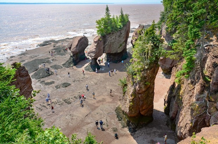 Aerial view of the people walking around the towering rocks on the east coast of Canada