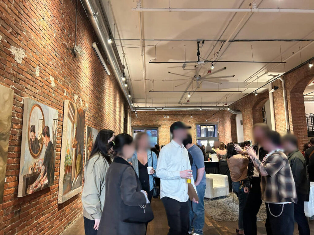 People gathering in the historic brick building with artworks around