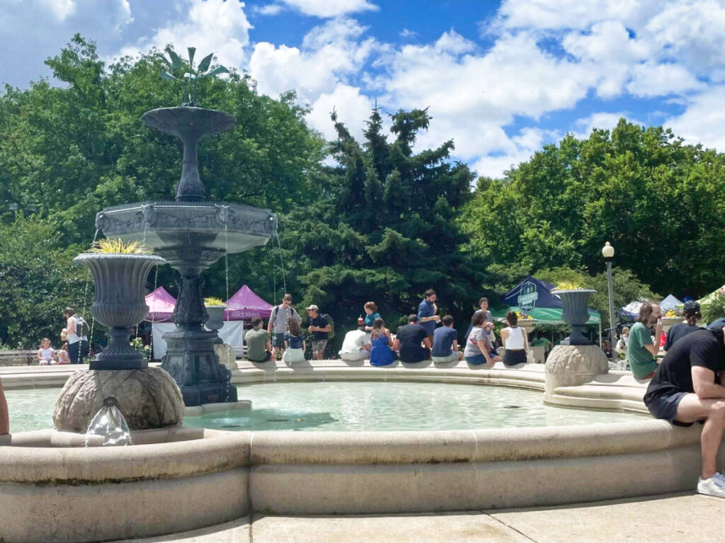 Crowd sitting around the huge fountain at the Wicker Park Farmers Market