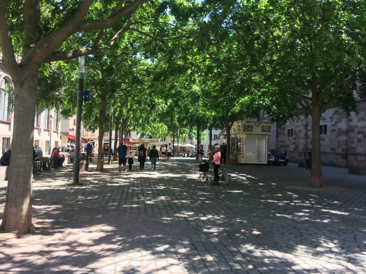 People walking on the shaded street in the city center