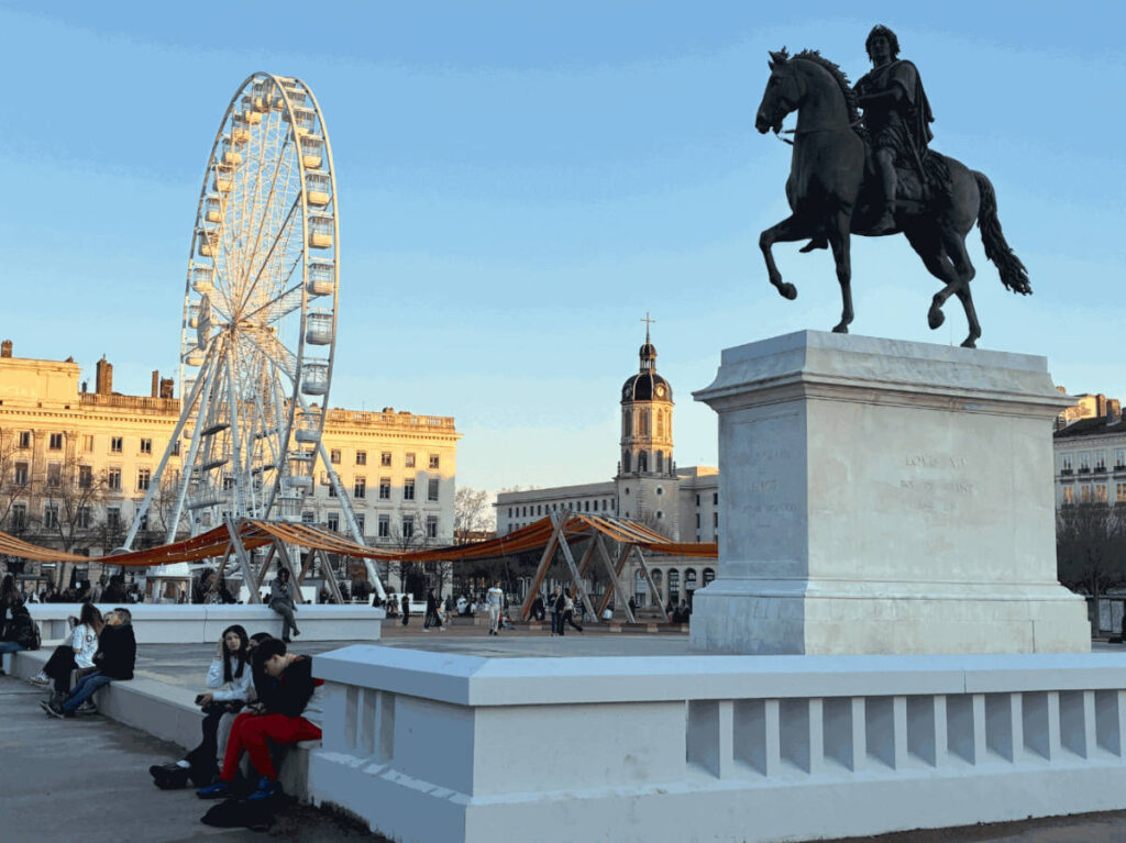 View of a statue and ferris wheel at the Place Bellecoeur