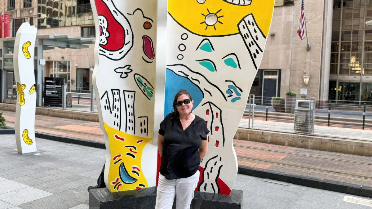 The author Karen Smith smiling for a photo with the Planter & Stems Sculpture