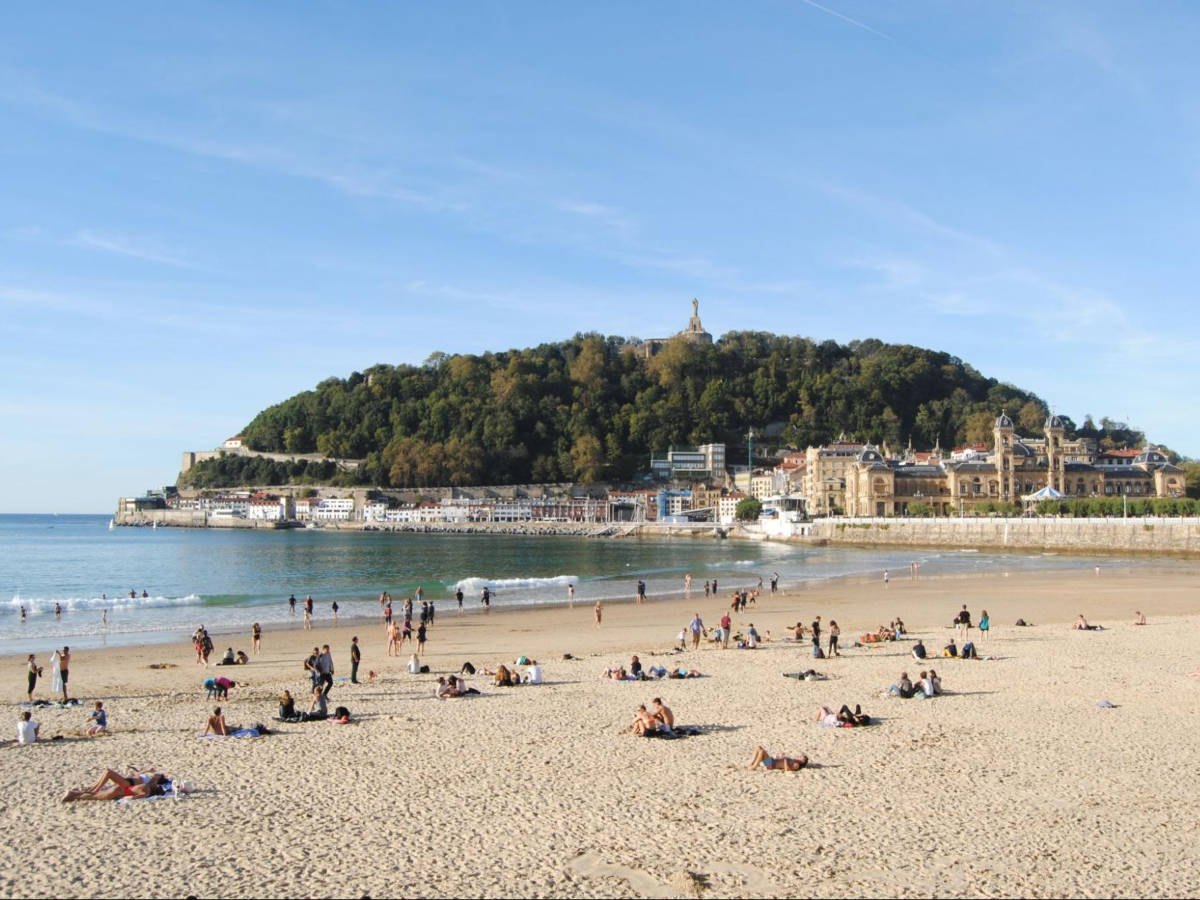 Panoramic view of the crowd along the shoreline with mountain views in Playa de la Concha